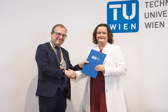 [Translate to English:] Lehrgangsleiter Bob Martens, Abolventin Cornelia Kratzer bei der Übergabe der Abschlussmappe