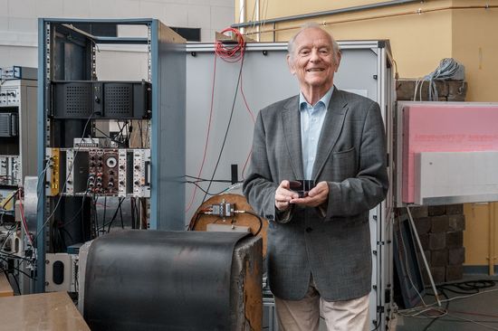 Prof. Helmut Rauch hält das Neutronen-Interferometer in den Händen. Im Hintergrund der Reaktor des Atominstituts. Foto: Nico Einsiedler