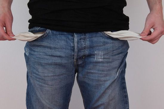 Person zieht das Taschenfutter der Jeanstaschen nach aussen