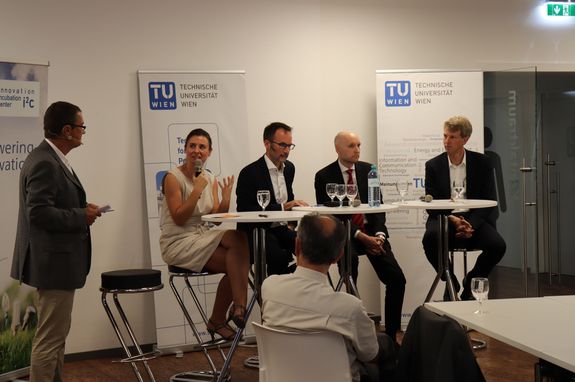 Erneute Aufnahme des Podiums und des Moderators, diesmal aus einem ganz neuen Winkel.
