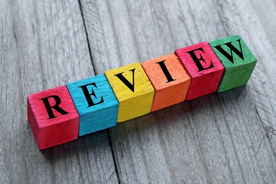bunte Bausteine auf grauer Tischplatte, Schrift in schwarz "Review"