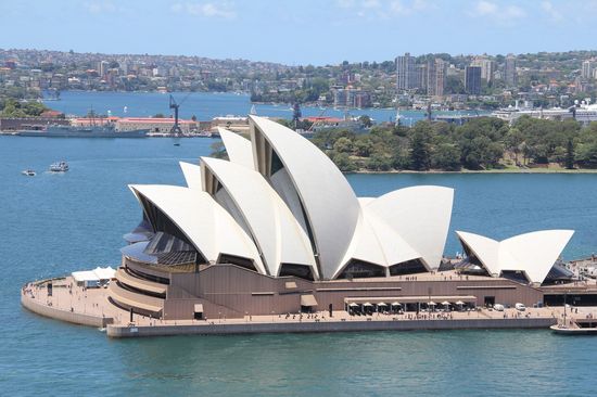  The Sydney Opera House with its white, sail-shaped roofs by the water.