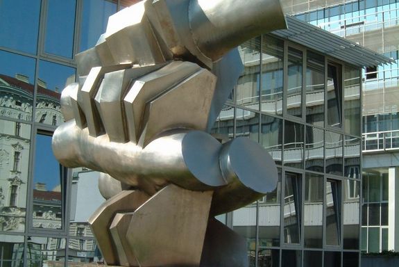 Porsche Denkmal Eine abstrakte Figur aus Stahl ist auf einem steinernen Sockel