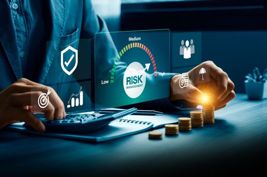 Risikomanagement- und Finanzstrategiekonzept mit einem Geschäftsmann, der Investitionsdaten analysiert und Vermögenswerte schützt, wobei er einen Taschenrechner und ein digitales Dashboard verwendet, um niedrige, mittlere und hohe Geschäftsrisiken zu bewerten.