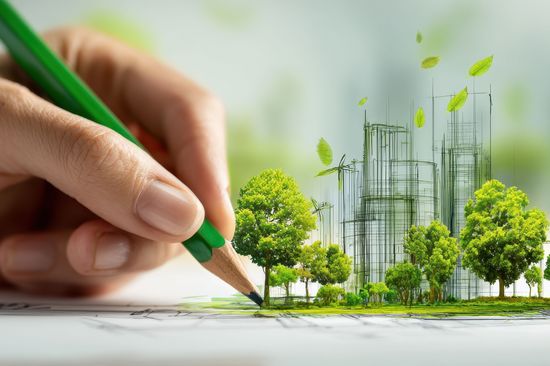 Eine Hand zeichnet eine nachhaltige Stadtentwicklung mit grünen Bäumen und Windkraftanlagen