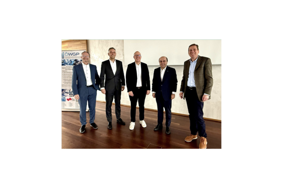 Group photo – from left to right: Christian Ramsauer (TU Graz), Sebastian Schlund (TU Wien, Fraunhofer Austria), Christoph Herrmann (TU Braunschweig, Fraunhofer IST), Fazel Ansari (TU Wien, Fraunhofer Austria), Harald Loos (Siemens). You can see five men in suits. On the far left, you can see an ÖWGP roll-up banner.