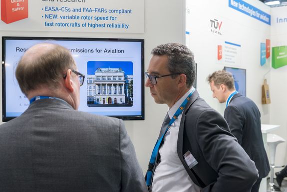 exhibitor and visitor talking to each other at teh TU Wien stand