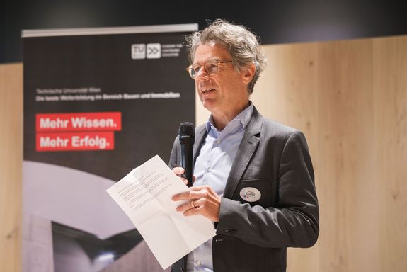 Wolfgang Güttel stehend mit Zettel in der Hand