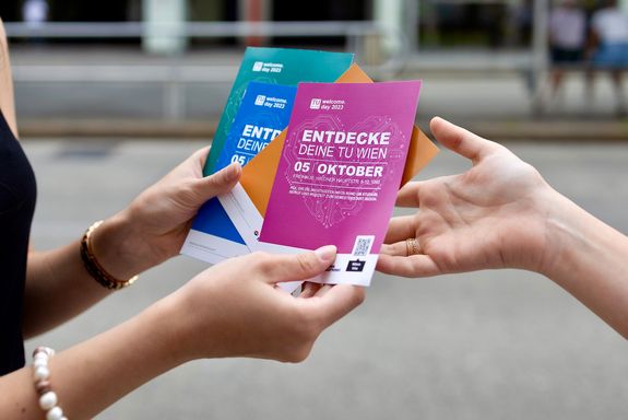 Großaufnahme 2 Hände die welcome.day Flyer halten