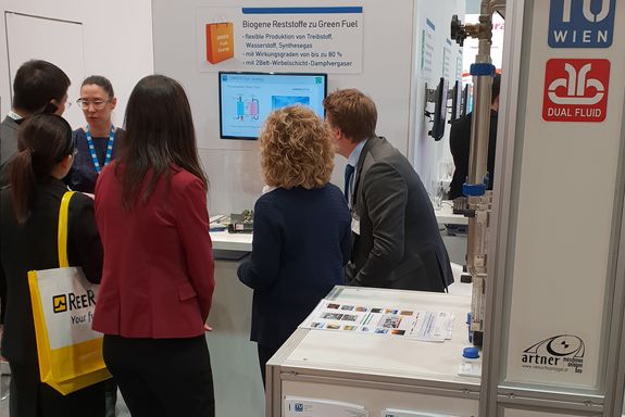 on the basis of a presentation on a flatscreen 4 people get a deeper explananation of the dual-fluid-bed gasifictaion by 2 members of the research team