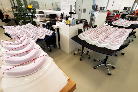 Unzählige Gesichtsschutzvisiere liegen in der Werkstatt bereit.