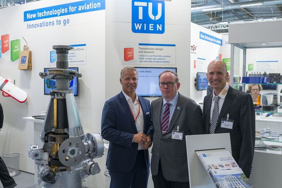 helicopter gearbox, left and 3 men on the right at the TU Wien stand