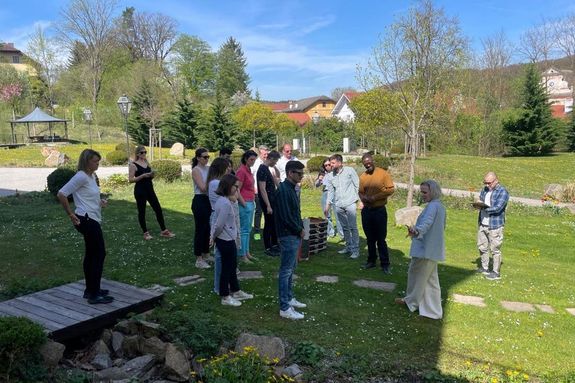 Außenaufnahme: Studierende stehend auf grüner Wiese