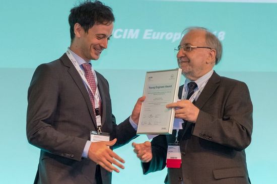 Freudige Preisübergabe mit Handeschütteln und Urkunde an Thomas Fuchslueger durch Prof. Leo Lorenz