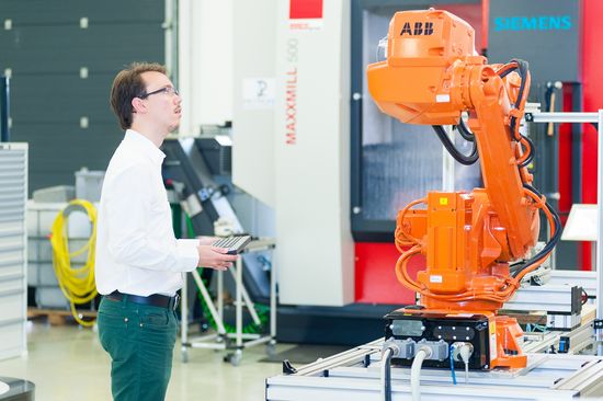 Mann steuert begeistert eine Maschine in der Pilotfabrik der TU Wien