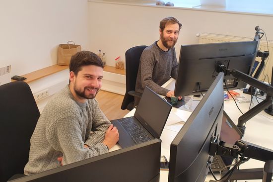 Sotiris und Max an ihrem Arbeitsplatz