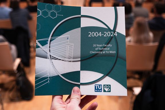 Hand hält Programm in Kamera