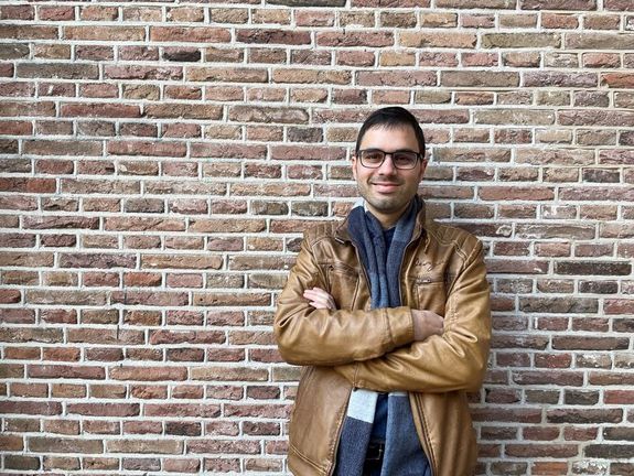 Marco De Paoli vor einer Ziegelmauer