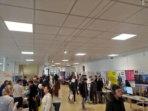 Exhibition hall with information stands, exhibitors and pupils