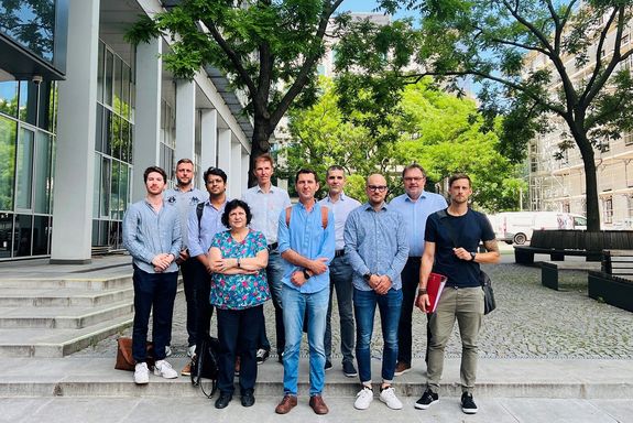 Einige Mitglieder des Projektteams, stehend vor Gebäude, Bäume und Parkbänke im Hintergrund.