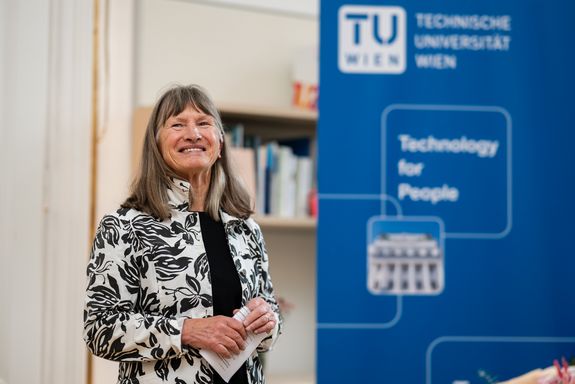 Künstlerin Lisl Spurny-Schwarzmüller neben einem TUW-Rollup