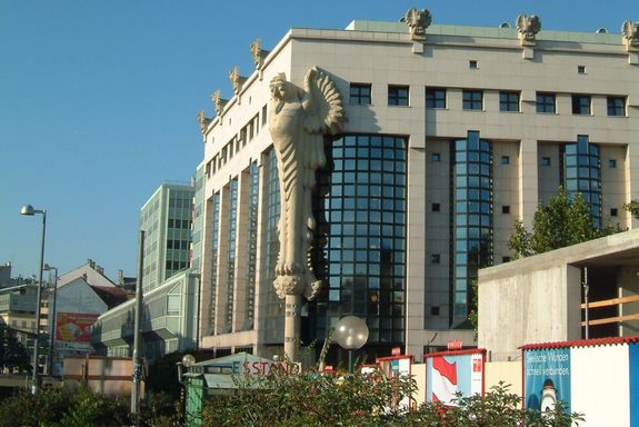 Bibliothek Das Bibliotheksgebäude von außen, es hat mehrere Stockwerke und eine Abbildung von Eule an der Ecke