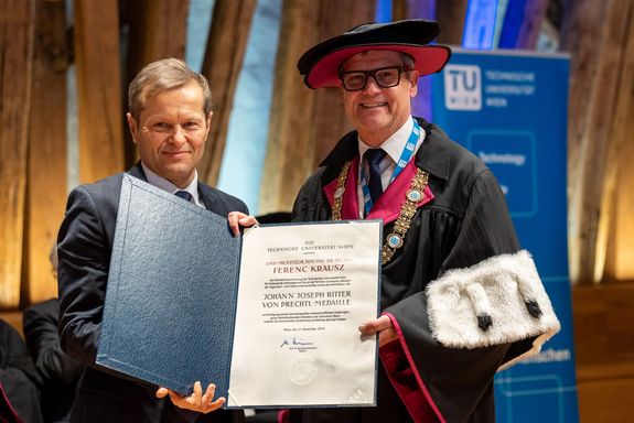 Ferenc Krausz und Rektor Schneider im Talar präsentieren die Urkunde zur Prechtl-Medaille
