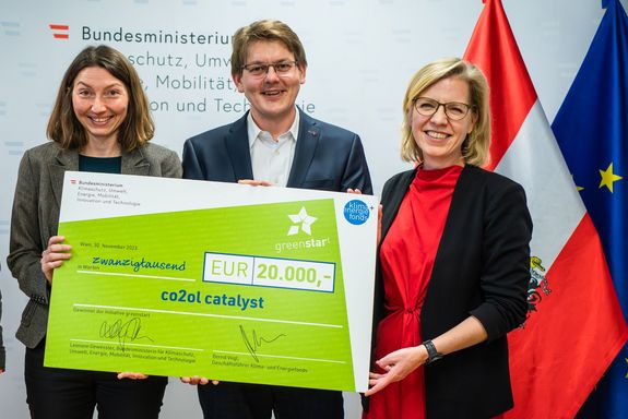 Drei Personen bei der Überreichung eines Schecks im Wert von 20.000 Euro