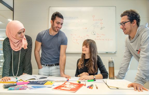 Studierende an einem Gruppenarbeitstisch