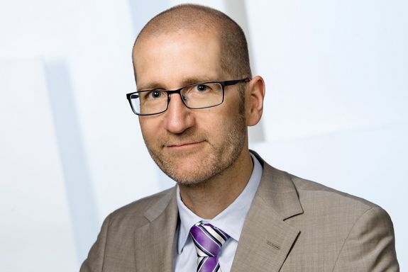 Ein Portrait von Prof. Michael Getzner. Er trägt Brille. Millimeterhaarschnitt, Sakko und Krawatte.