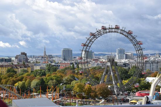 „Wiener Riesenrad im Prater mit Stadt und Bäumen im Vordergrund.“