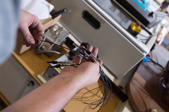 One hand holds several different cables