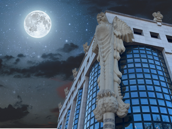 TUW Bibliothek mit Eule im Vordergrund und Nachthimmel mit Mond im Hintergrund 