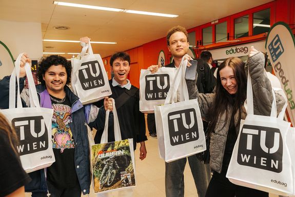 Menschen mit Goodiebags in der Hand lachen in Camera