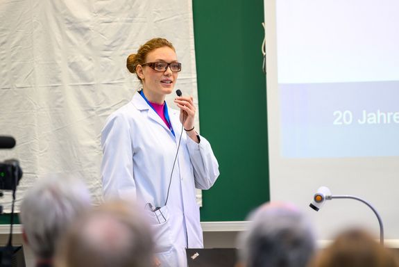 Frau mit Labormantel und Mikro