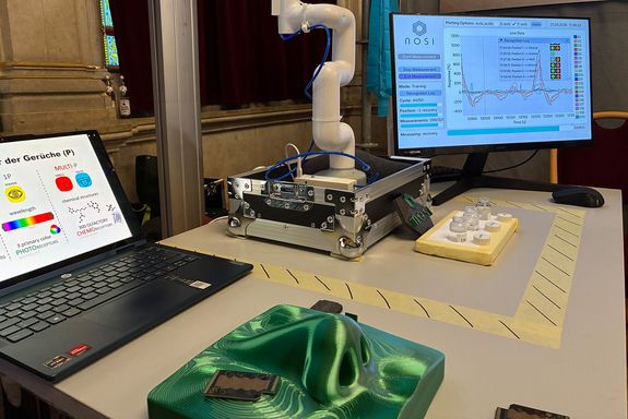 Ein Modell einer Nase, im Hintergrund ein Roboterarm.