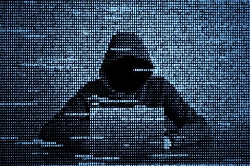 Person im Hoodie vor Notebook 