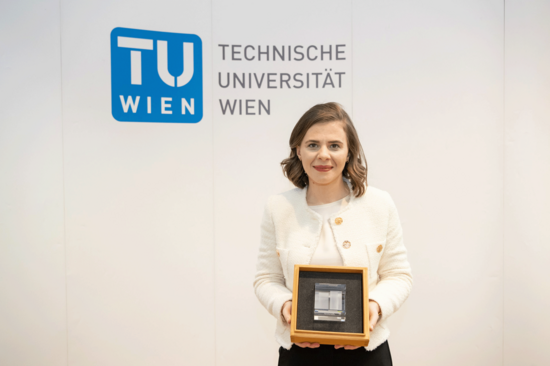 Nermina Mumic präsentiert den TUW-Frauenpreis. Sie trägt Weiß, Bild in Weiß gehalten.