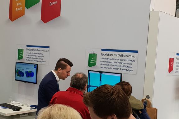 Two exhibitors (TU Wien) talking to some visitors at the TU Wien stand.