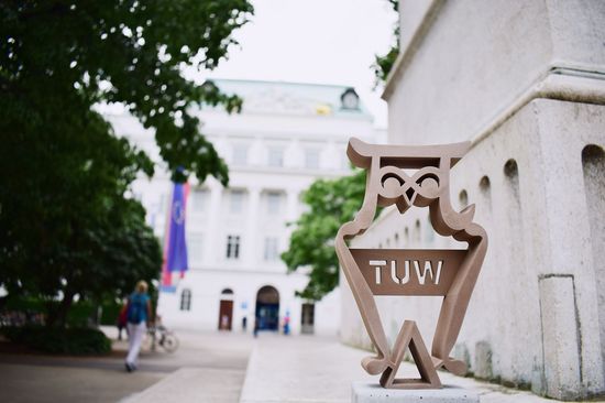im Vordergrund Best Teaching Award Eule, im Hintergrund Haupteingang TU Wien