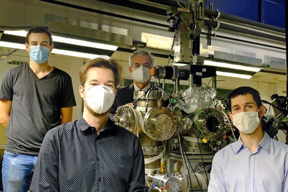 Vier Personen mit Nasen-Mund-Schutz im Labor