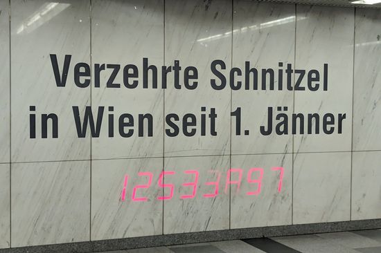 Das Foto zeigt einen Schriftzug mit zugehöriger Zahl, die permanent aktualisiert wird, an einer Wand in der Karlspassage in Wien.