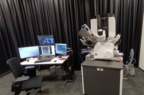 Mikroskop, daneben ein Computerbildschirm