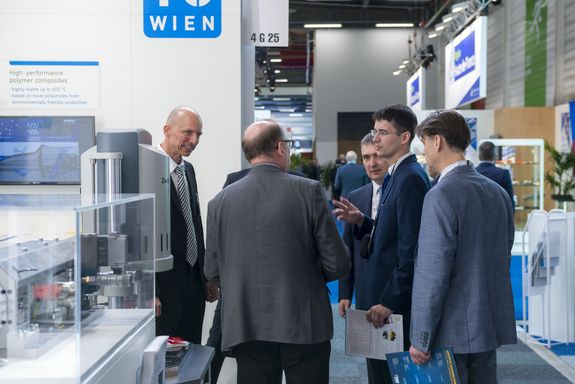 three exhibitors talking tio three visitors at the TU Wien stand