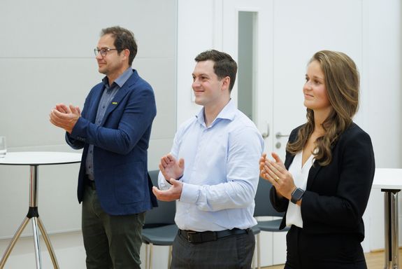 Gruppenfoto von 3 applaudierenden Stipendiat_innen: Rainer Wohlschlager (PALFINGER), Daniel Mazanek (Data Science), Pia Schwarzinger (Data Science) (von links) 