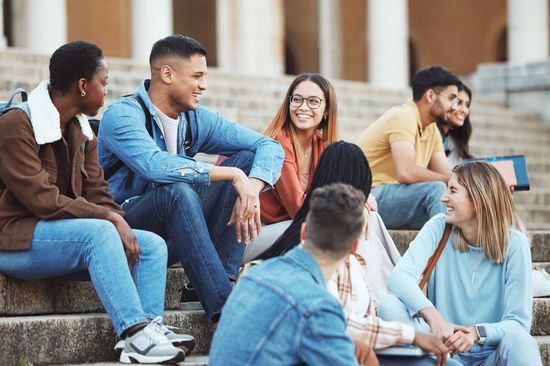 Eine Gruppe an Studierenden sitzt und unterhält sich.