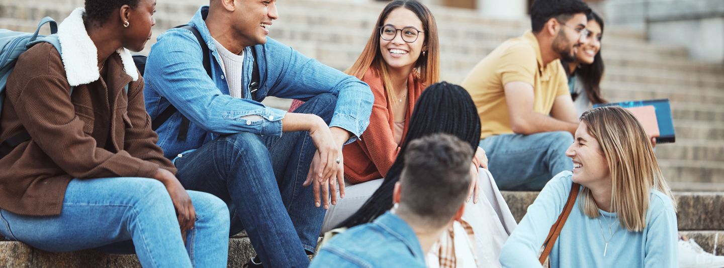 Eine Gruppe an Studierenden sitzt und unterhält sich.
