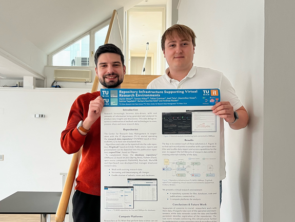 Sotirios Tsepelakis und Martin Weise stehen nebeneinander und halten ein Poster mit dem Titel "Repository Infrastructure Supporting Virtual Research Environments" in den Händen.