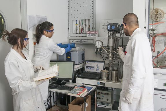 MitarbeiterInnen der Arbeitsgruppe Unterlass bereiten einen Versuch mit Hochtemperatur-Infrarot- Sonde und Reaktor vor. (Im Bild v.l.n.r.: Catarina I.O. Martins, Sofia Torres Venegas und Daniel A. Cerrón Infantes)