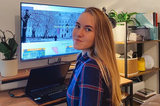 Evgeniia sitzt an ihrem Arbeitsplatz vor dem PC. 